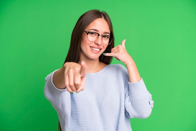 Sonriendo alegremente y señalando a la cámara mientras hace una llamada, luego gesticula hablando por teléfono