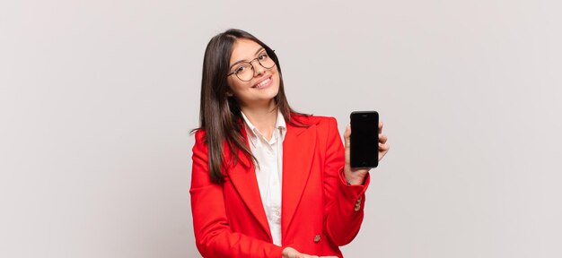 sonriendo alegremente sintiéndose feliz y mostrando un concepto en el espacio de la copia con la palma de la mano