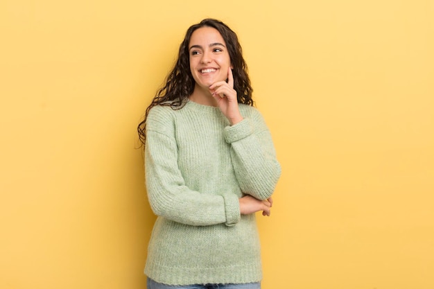 Sonriendo alegremente y soñando despierto o dudando mirando hacia un lado