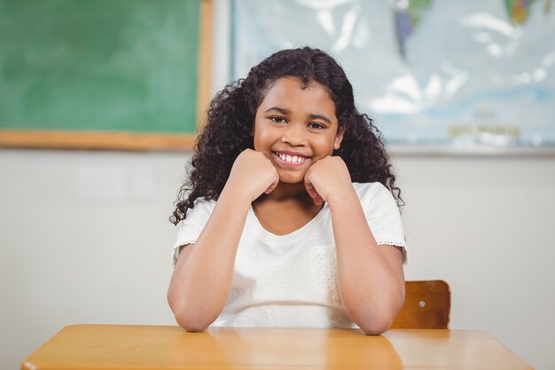 Sonriendo alumno sentado en un aula