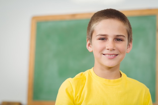 Sonriendo alumno sentado en un aula