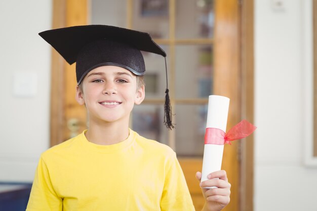 Foto sonriendo alumno con tablero de mortero y diploma