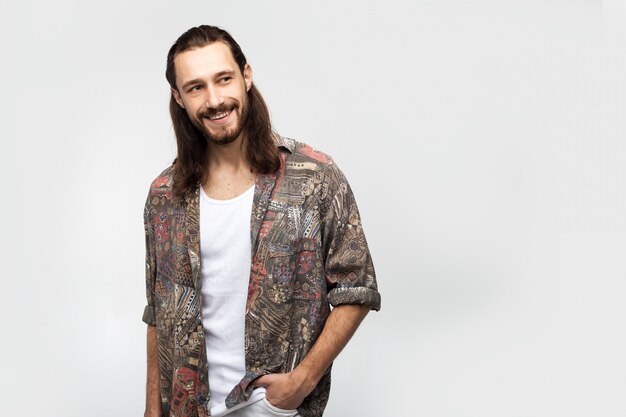 Sonriendo amigable divertido chico, atractivo y amable hippie. Hipster viajero elegante hombre despreocupado sobre un fondo blanco de estudio, estilo de vida de las personas