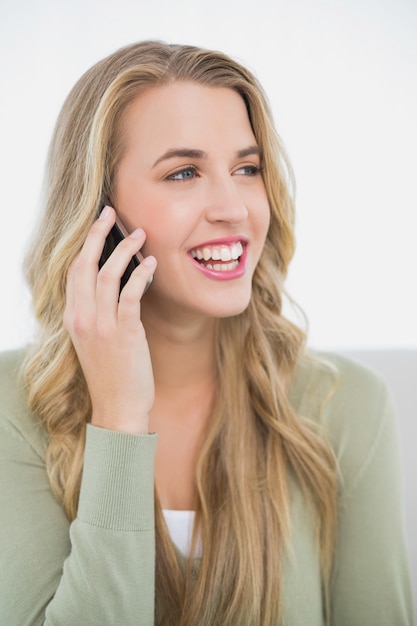 Sonriendo bonita rubia en el teléfono