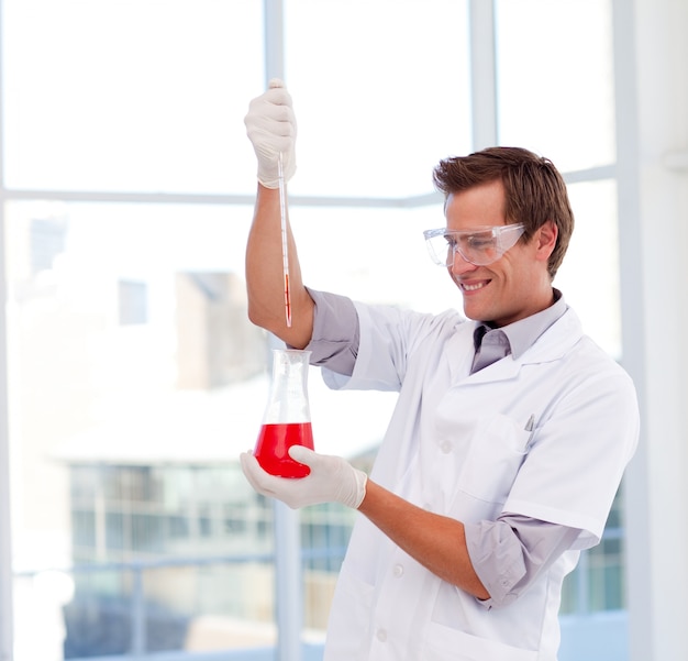 Sonriendo científico examinar un tubo de ensayo