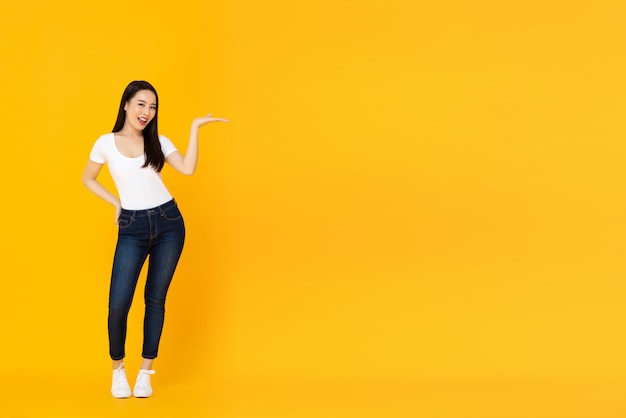 Sonriendo confía joven hermosa modelo femenino asiático haciendo un gesto de palma abierta