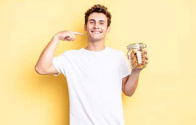 Sonriendo con confianza apuntando a su propia sonrisa amplia, actitud positiva, relajada y satisfecha. concepto de galletas caseras