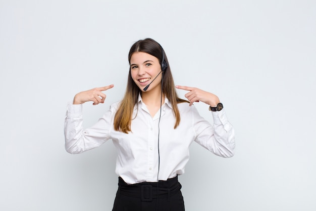 sonriendo con confianza apuntando a su propia sonrisa amplia, actitud positiva, relajada y satisfecha