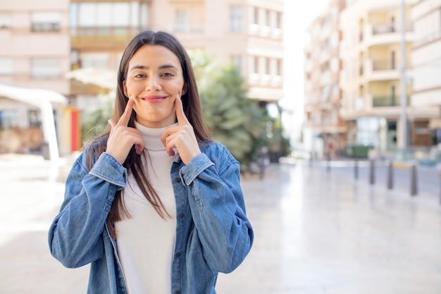 Foto sonriendo con confianza apuntando a su propia sonrisa falsa