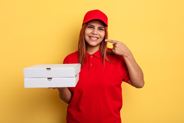 sonriendo con confianza señalando su propia sonrisa amplia