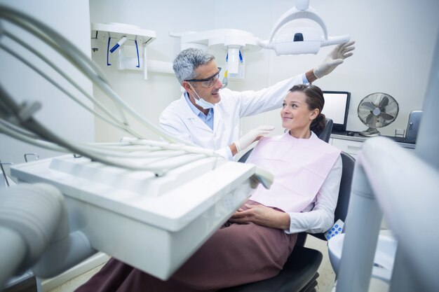 Sonriendo dentista hablando con el paciente