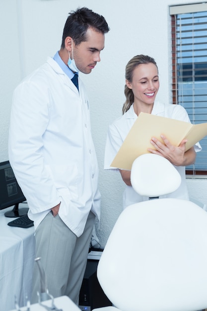 Sonriendo dentistas discutiendo informes