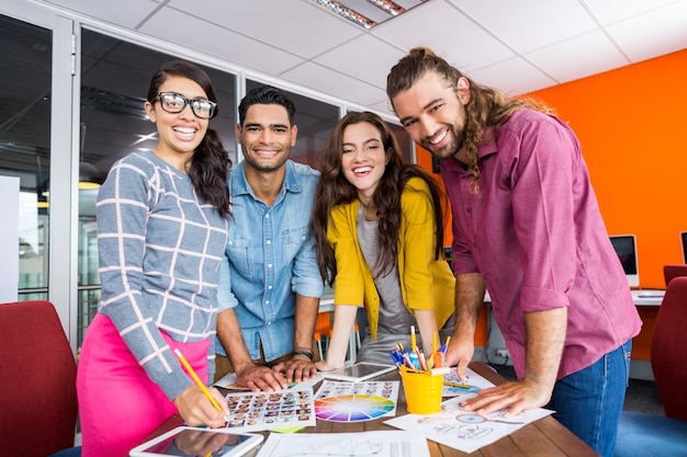 Sonriendo diseñadores gráficos trabajando sobre fotos en el escritorio en la oficina