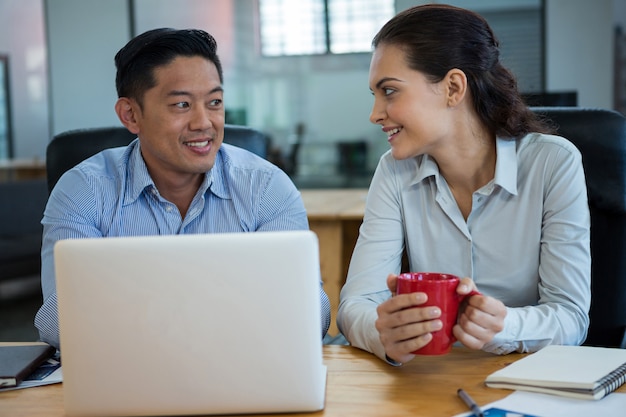 Sonriendo ejecutivos de negocios discutiendo entre sí