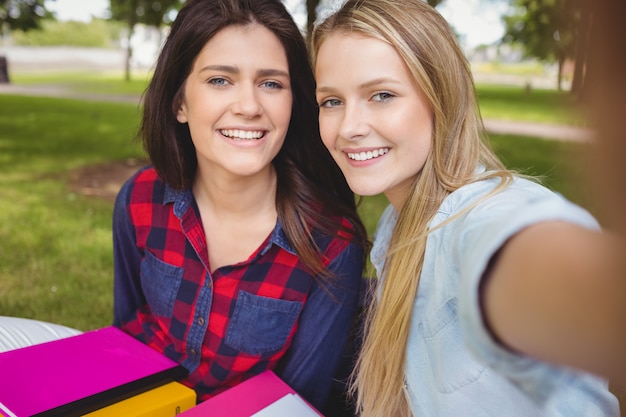 Sonriendo estudiantes estudiando al aire libre en el parque