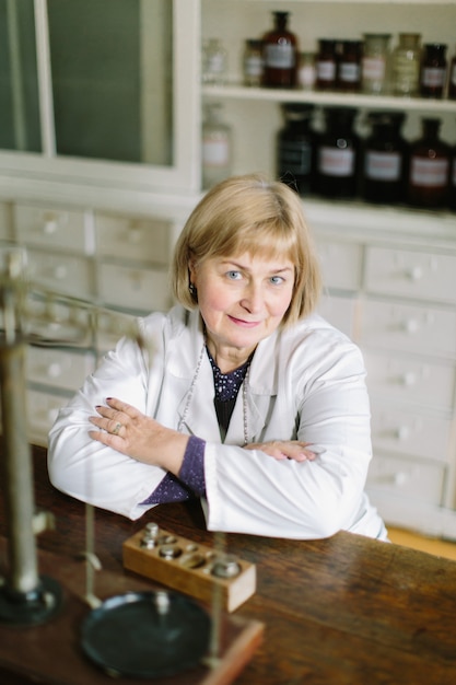 Sonriendo farmacéutico e lady de mediana edad en la farmacia