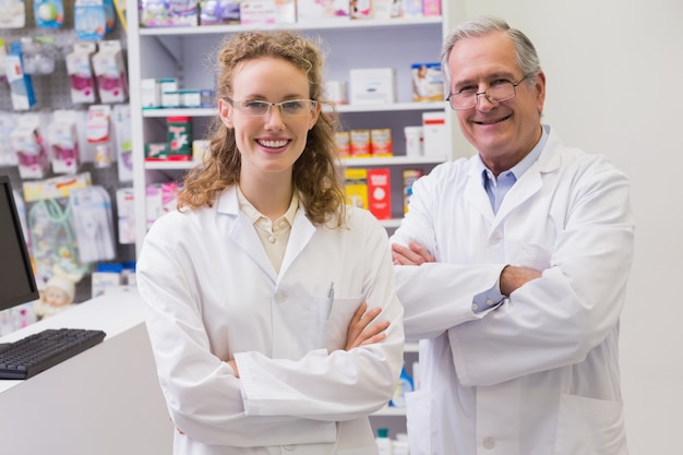 Sonriendo farmacéuticos con los brazos cruzados