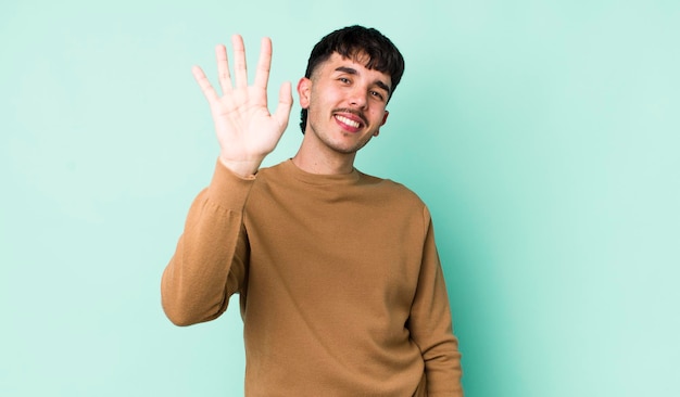 sonriendo feliz y alegremente agitando la mano dándote la bienvenida y saludándote o despidiéndote