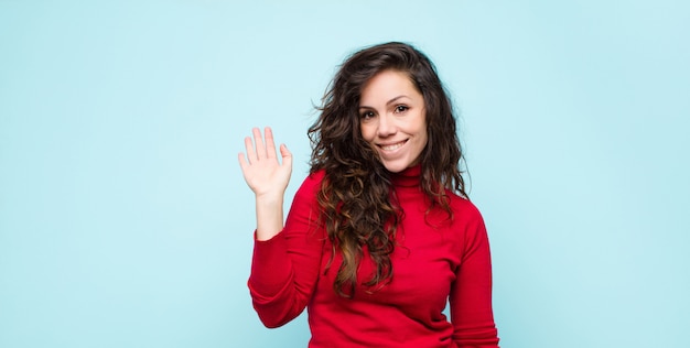 sonriendo feliz y alegremente, saludando con la mano, dándote la bienvenida y saludándote, o diciéndote adiós