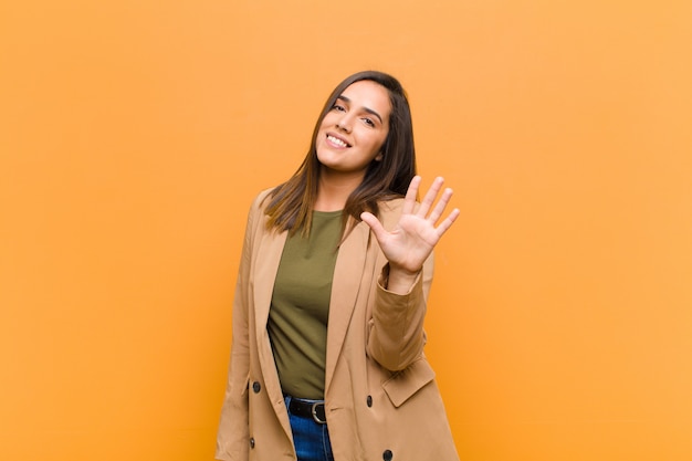 sonriendo feliz y alegremente, saludando con la mano, dándote la bienvenida y saludándote, o diciéndote adiós