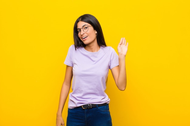 sonriendo feliz y alegremente, saludando con la mano, dándote la bienvenida y saludándote, o diciéndote adiós