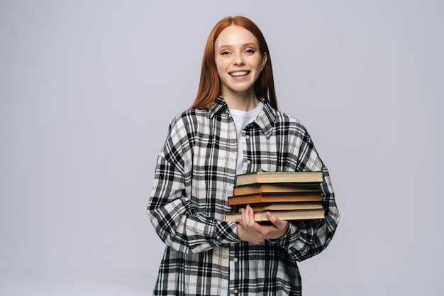 Sonriendo feliz joven estudiante universitario vistiendo ropa de moda casual sosteniendo libros