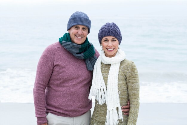 Sonriendo feliz pareja ambos con bufandas y sombreros