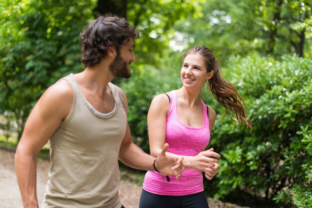 Sonriendo feliz pareja corriendo en un parque