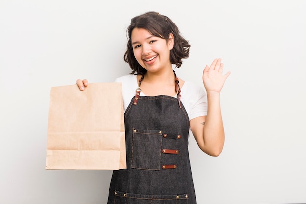 Sonriendo felizmente agitando la mano dándote la bienvenida y saludándote