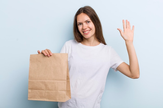 Sonriendo felizmente agitando la mano dándote la bienvenida y saludándote