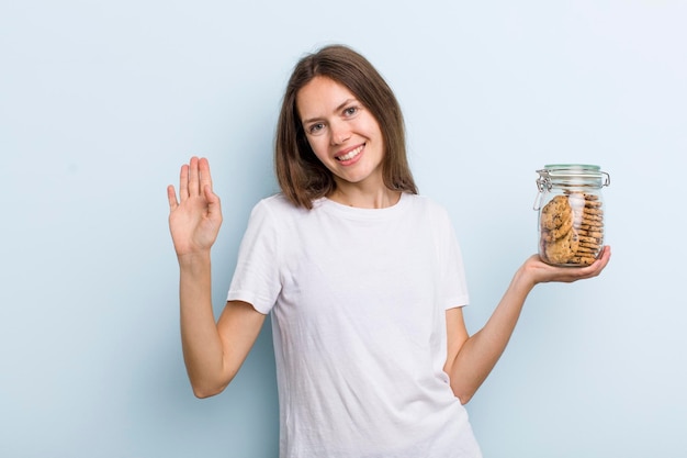 Sonriendo felizmente agitando la mano dándote la bienvenida y saludándote