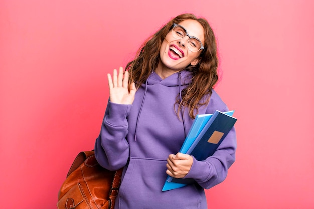 Sonriendo felizmente agitando la mano dándote la bienvenida y saludándote