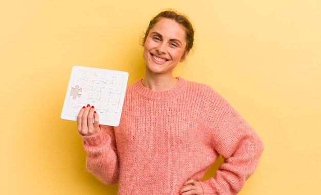 sonriendo felizmente con una mano en la cadera y confiado