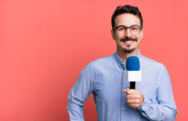 sonriendo felizmente con una mano en la cadera y confiado