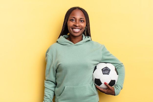 Sonriendo felizmente con una mano en la cadera y confianza en el concepto de fútbol de actitud positiva, orgullosa y amistosa