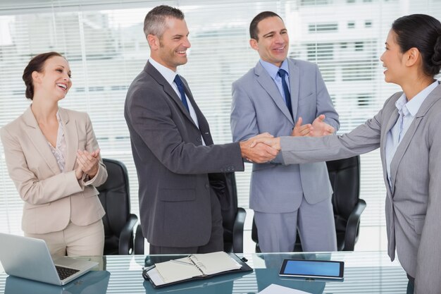 Foto sonriendo futuros compañeros de trabajo dándose la mano