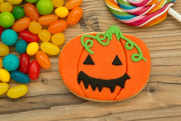 Sonriendo galleta de calabaza con muchos dulces coloridos