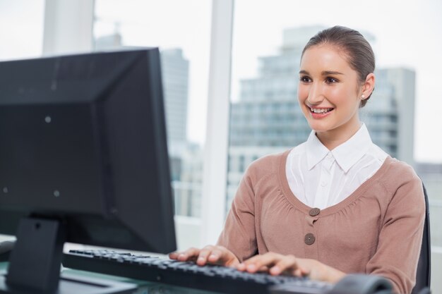 Sonriendo hermosa empresaria trabajando en su computadora
