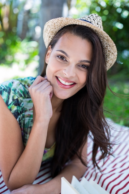 Foto sonriendo hermosa morena acostada en la manta