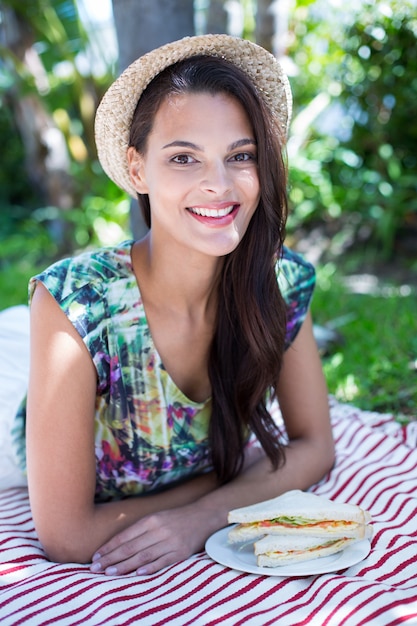 Sonriendo hermosa morena teniendo un picnic