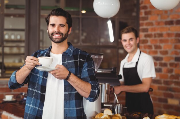 Sonriendo hipster tomando café frente a barista