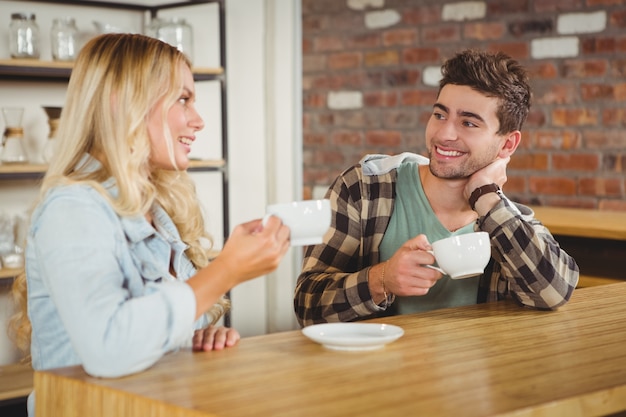 Sonriendo hipsters hablando y disfrutando de café juntos