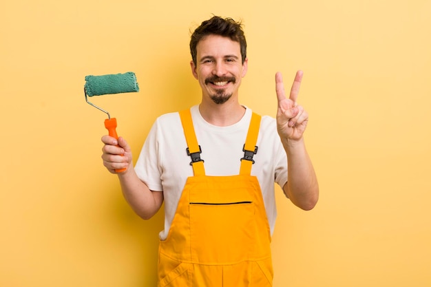 Sonriendo y luciendo amigable mostrando el concepto de hogar de pintura número dos