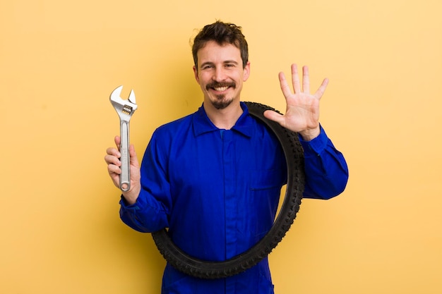 Sonriendo y luciendo amigable mostrando el concepto de reparador de bicicletas número cinco