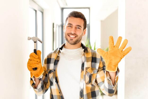 Foto sonriendo y luciendo amigable, mostrando el número cinco o quinto con la mano hacia adelante, contando hacia atrás