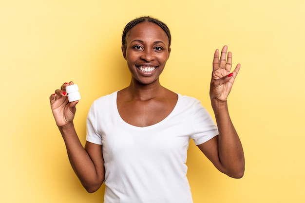 Sonriendo y luciendo amigable, mostrando el número cuatro o cuarto con la mano hacia adelante, contando hacia atrás. concepto de pastillas