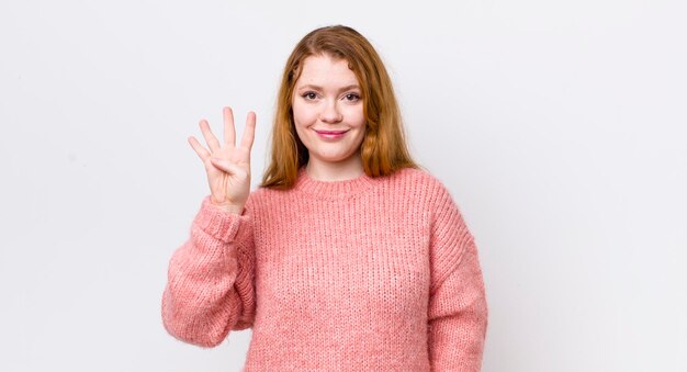 Sonriendo y luciendo amigable mostrando el número cuatro o cuarto con la mano hacia adelante contando hacia atrás