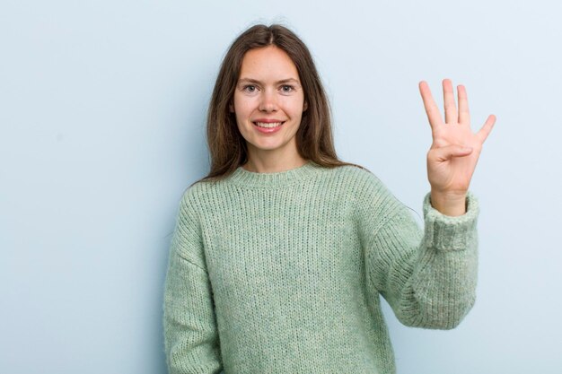 Sonriendo y luciendo amigable mostrando el número cuatro o cuarto con la mano hacia adelante contando hacia atrás