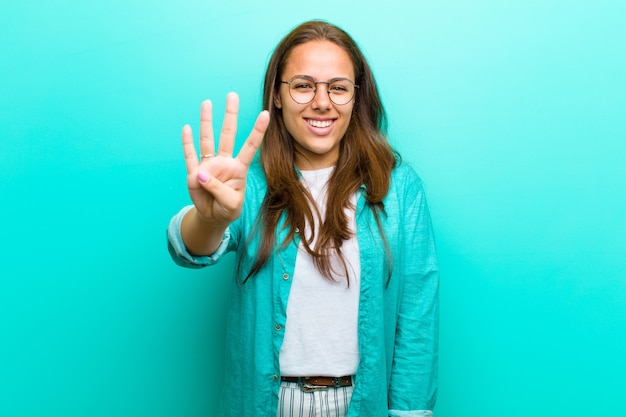 sonriendo y luciendo amigable, mostrando el número cuatro o cuarto con la mano hacia adelante, contando hacia atrás