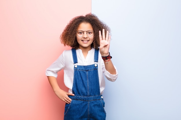 sonriendo y luciendo amigable, mostrando el número cuatro o cuarto con la mano hacia adelante, contando hacia atrás